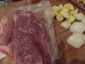schweinebraten_1 Ca. 1 Kilo Schweinebraten (Kamm, Nacken) mit Salz und Pfeffer einreibe. Je 2 Äpfel und Zwiebeln schälen und vierteln. Den Ofen auf 180° vorheizen.